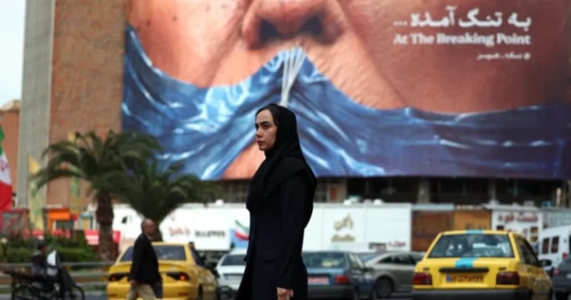 a-woman-walks-past-an-anti-us-billboard-depicting-president-trump-in-valiasr-square-in-tehran-b284c4ded0420dfe3dc1feba0b420f2d1777720282.jpg