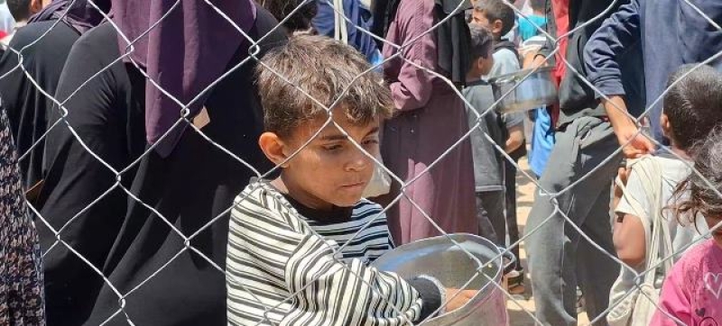 a-palestinian-child-in-gaza-after-receiving-a-meal-during-food-distribution-in-central-gaza-8fb1115944687c729f79099383f9bf061747244038.jpg